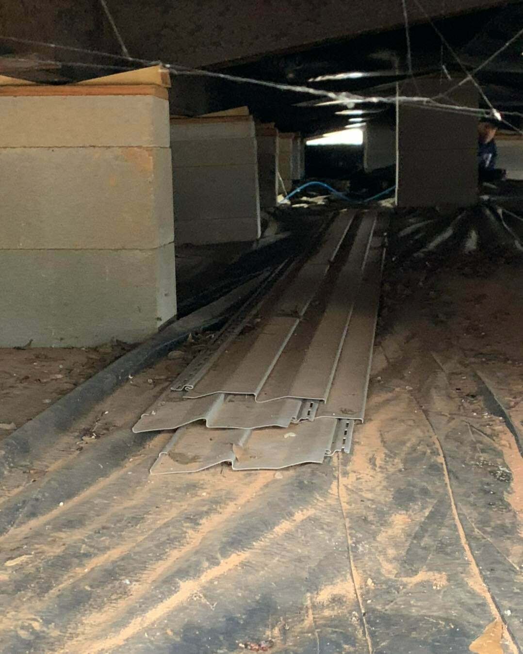 Crawl space with concrete block supports and moisture barrier installed under a manufactured home in East Texas.