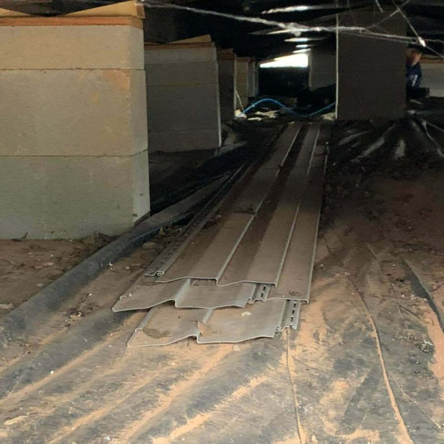 Crawl space with concrete block supports and moisture barrier installed under a manufactured home in East Texas.