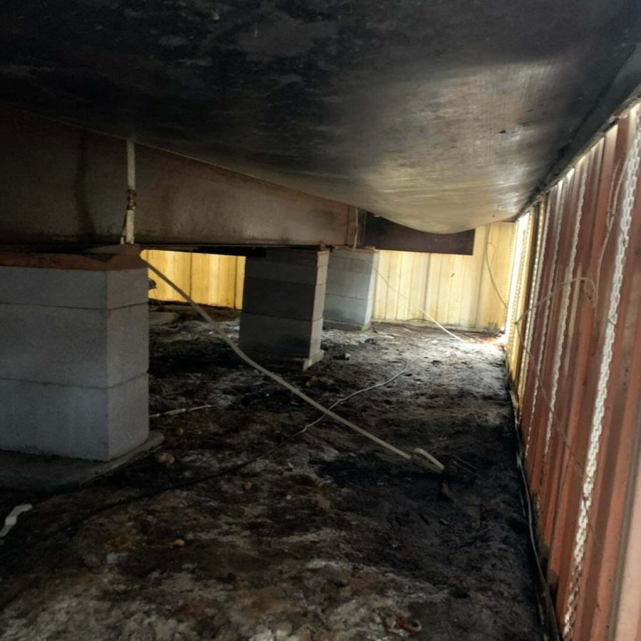 Crawl space under a manufactured home in Gilmer, TX showing concrete block supports and structural bracing.
