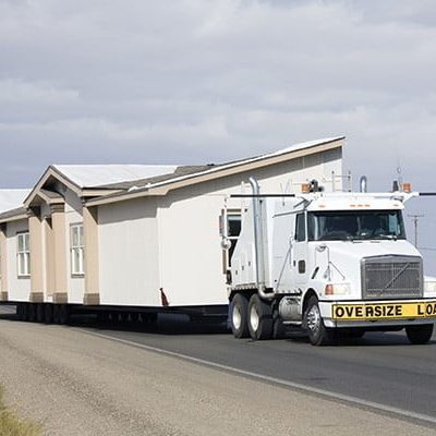 Truck transporting oversized mobile home